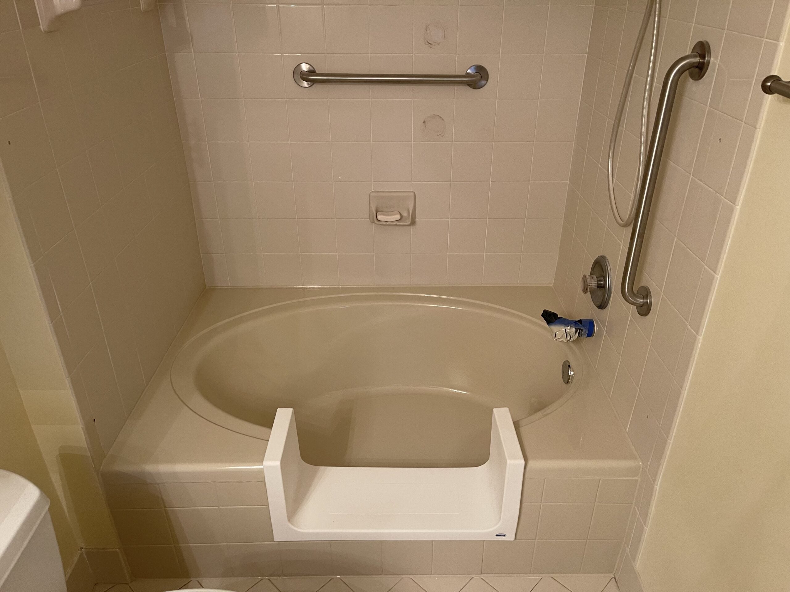 CleanCut Deep Step cutout installed in an oval bathtub with grab bars