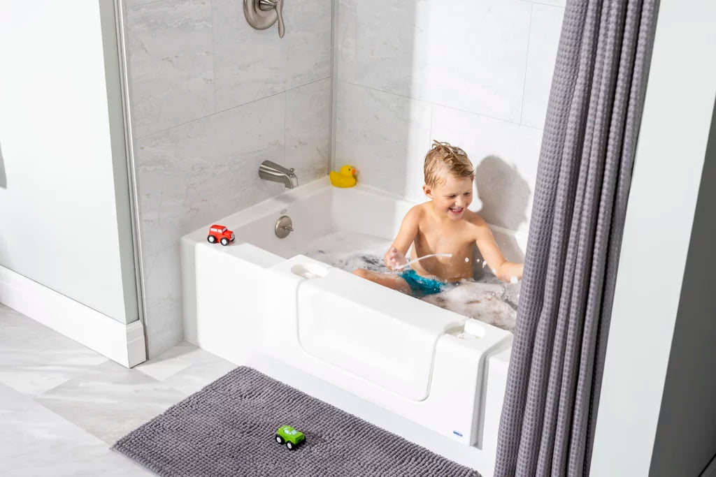 Child bathing in a full tub fitted with the CleanCut Convertible insert